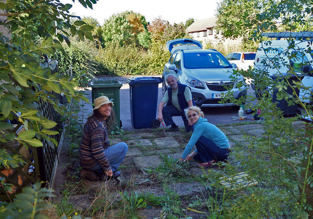 Members of the St Neots timebanking  at work clearing weeds from a patio.